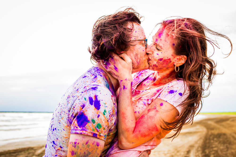 Couple kisses while covered in Holi powder