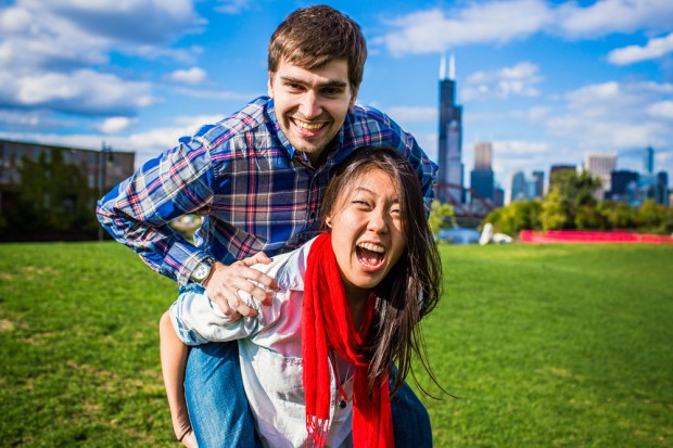 Woman gives man a piggy pack ride during a fun engagement session