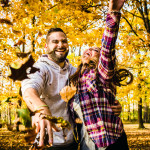 Couple throws leaves during their fall engagement session.