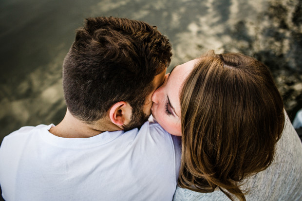 Couple kisses on a dock during their lake house engagement session