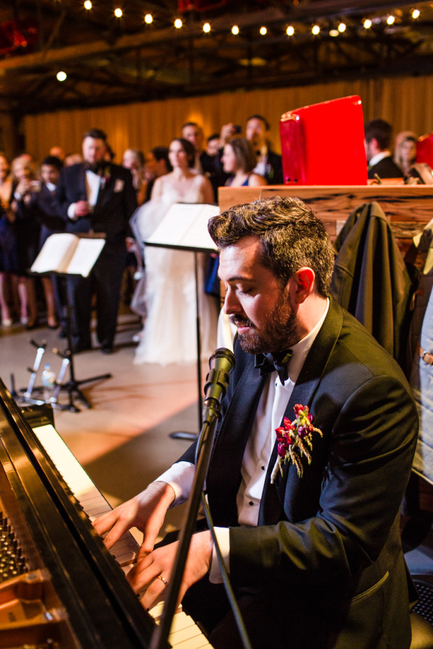 Groom plays the piano during an Ovation Chicago wedding reception.