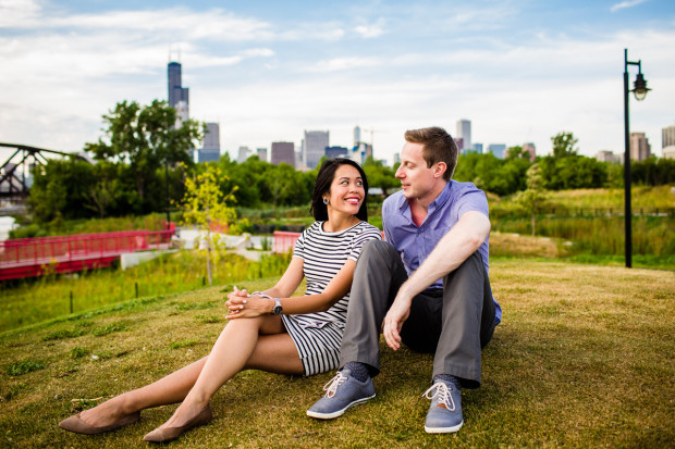 A couple relaxes on the grass during their Ping Tom Park engagement session