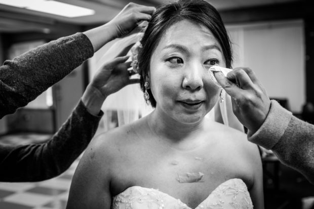 Bride has tears wiped from her eyes before a wedding ceremony at Lakeview Church.