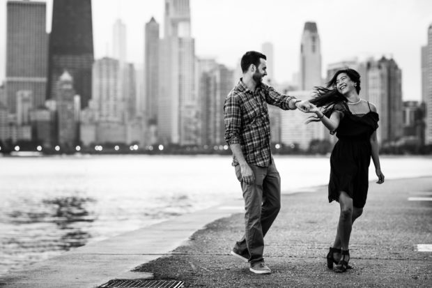 A couple laughs together during their North Avenue Beach sunrise engagement session.