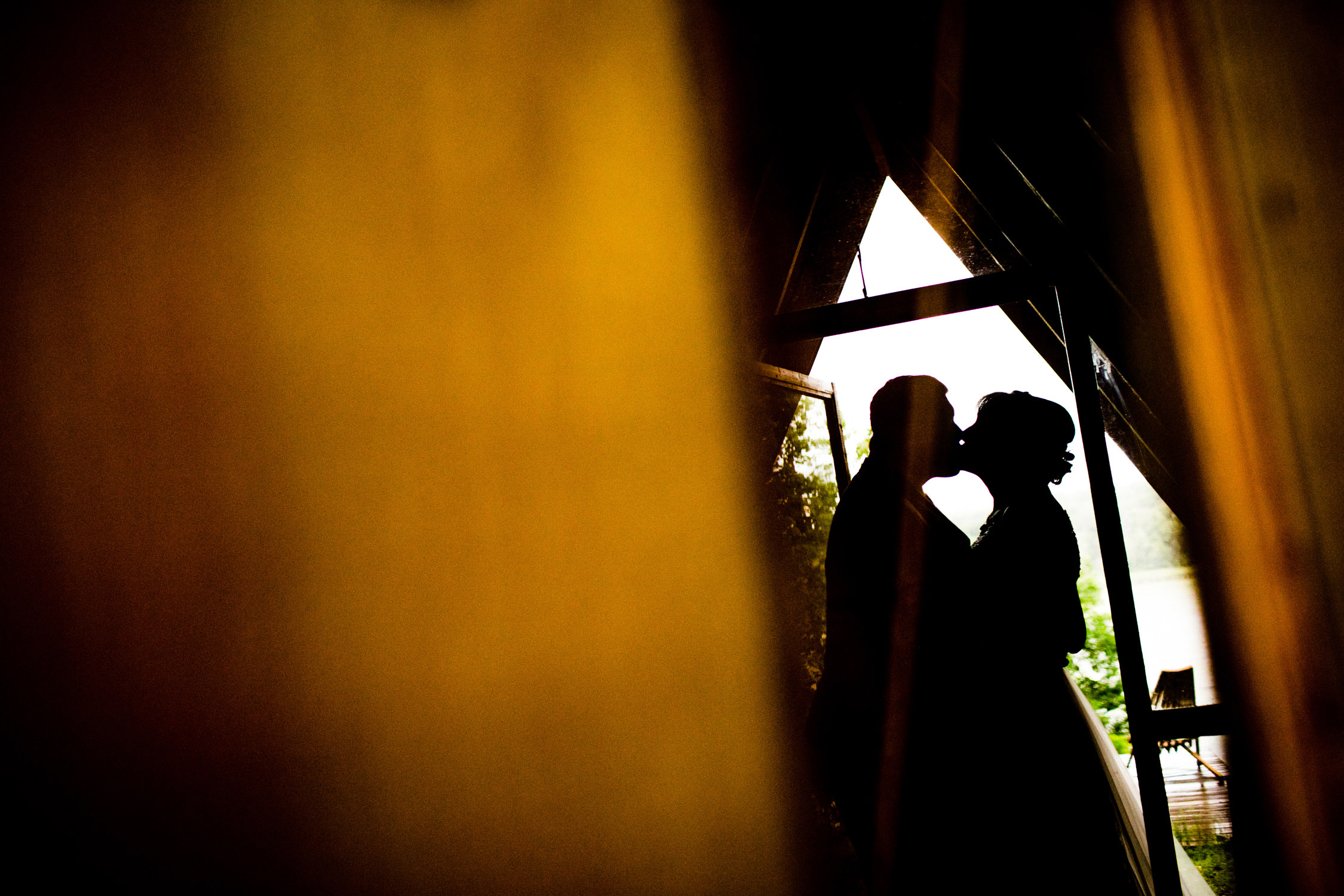 A couple kisses in silhouette at a Camp Wandawega wedding.