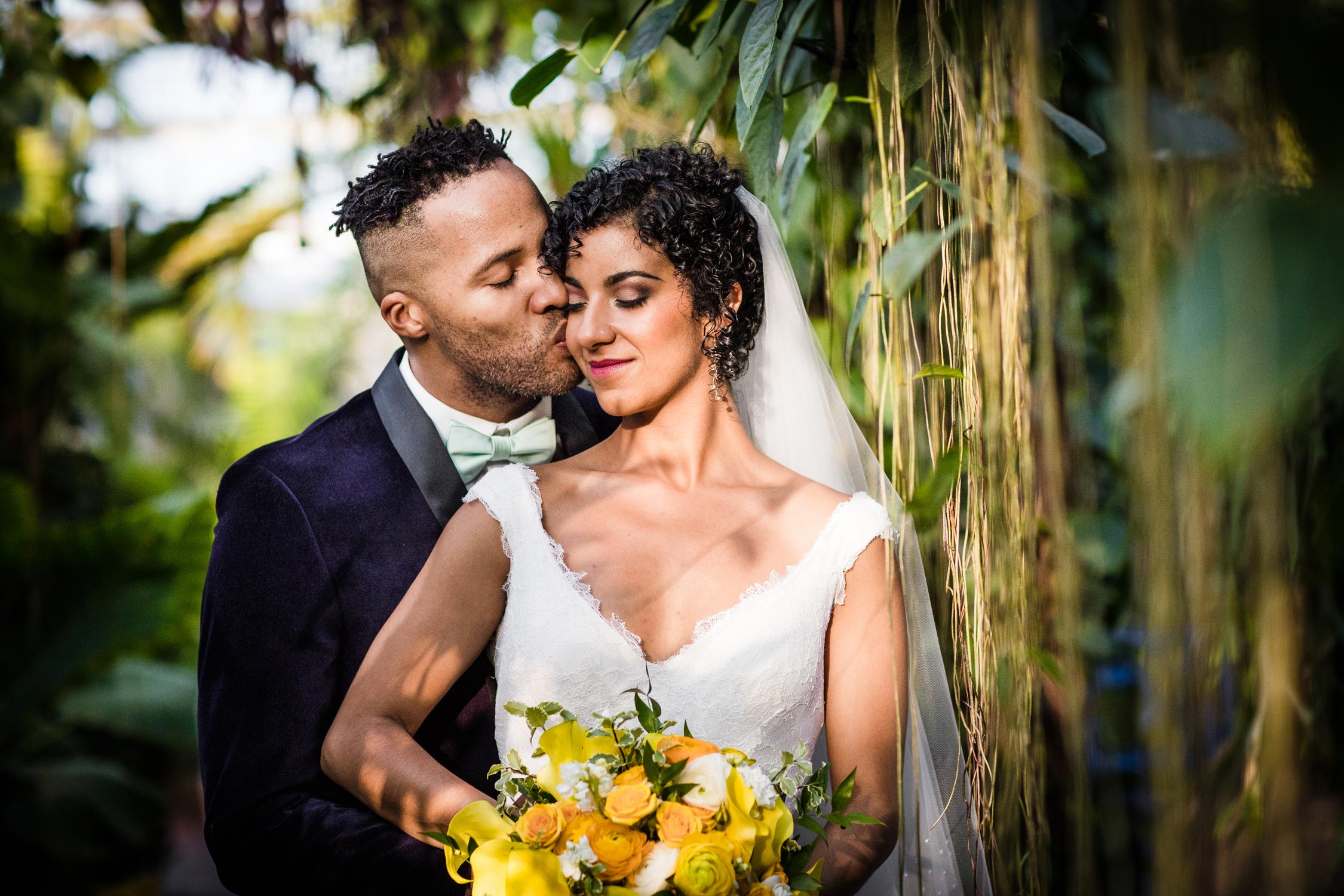 A couple kisses during a Garfield Park Conservatory wedding.