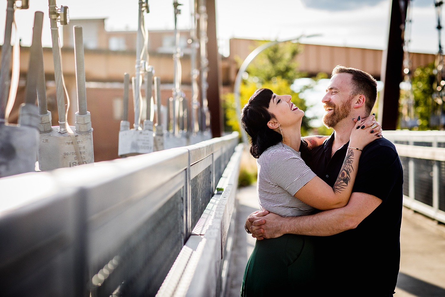 A couple laughs together on the 606 during their Logan Square engagement session in Chicago. 