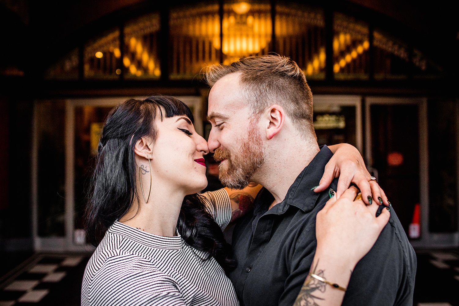 A couple shares a moment together outside the Logan Theater during their Logan Square engagement session in Chicago. 