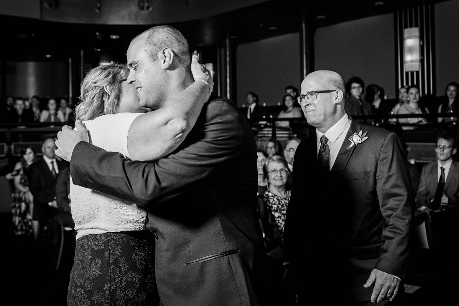 A groom hugs his parents at a Mayne Stage wedding in Chicago. 