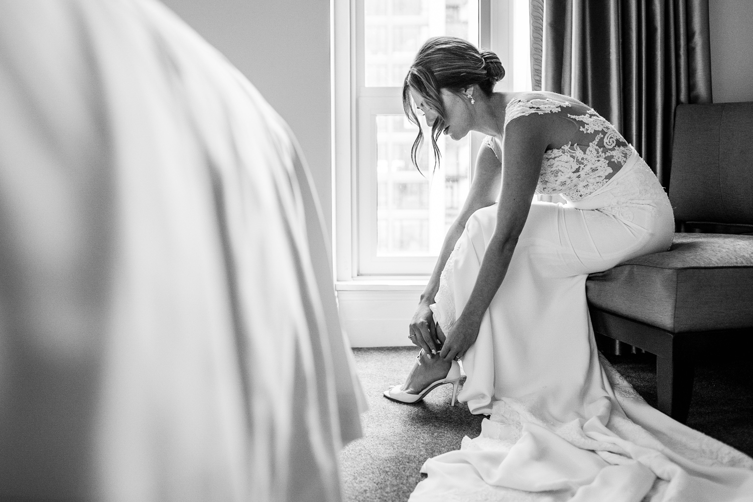 A bride puts on her shoes before a Gallery Marchetti wedding.