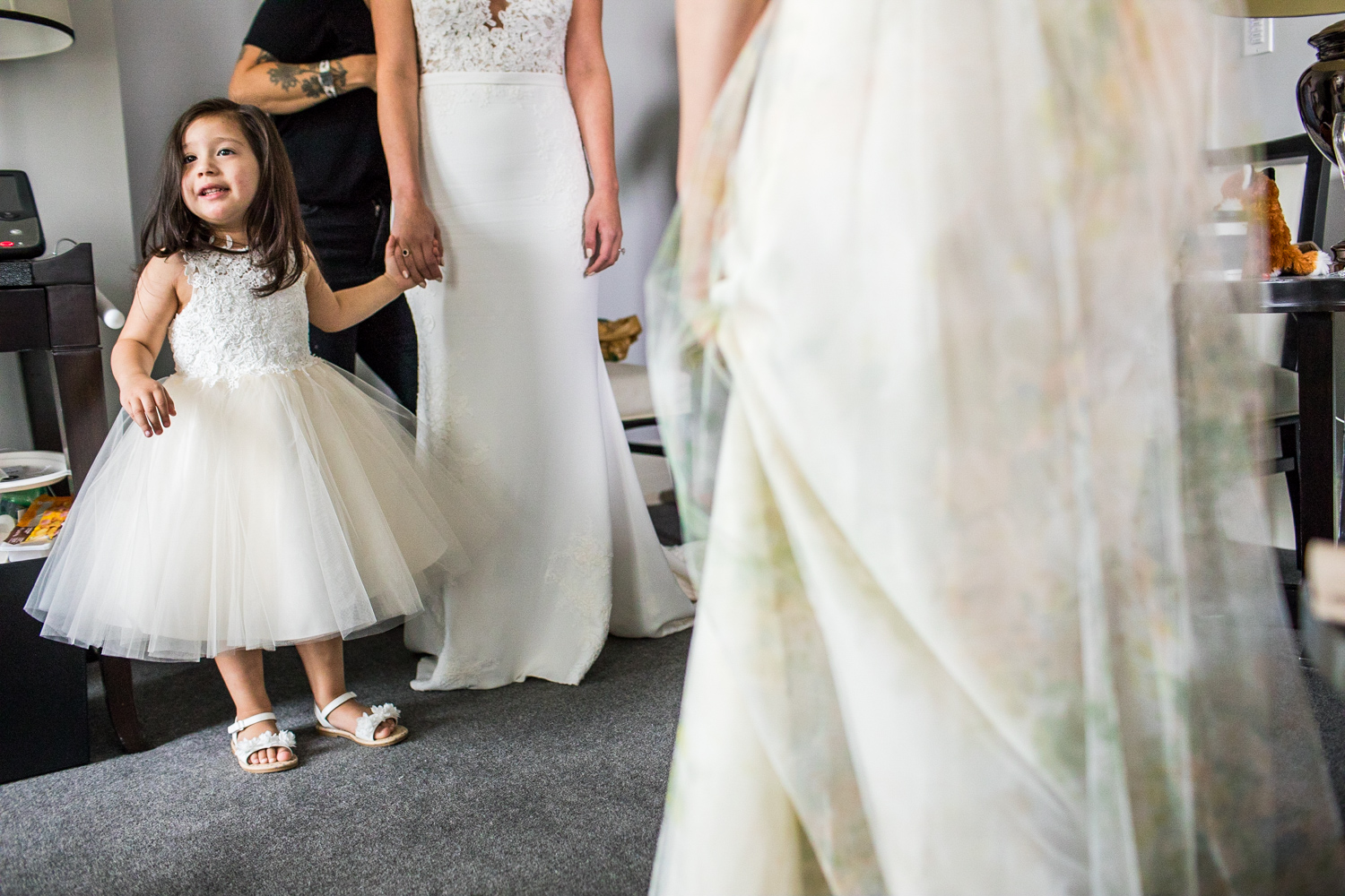 A bride holds the flower girl's hand while getting ready for a Gallery Marchetti wedding.