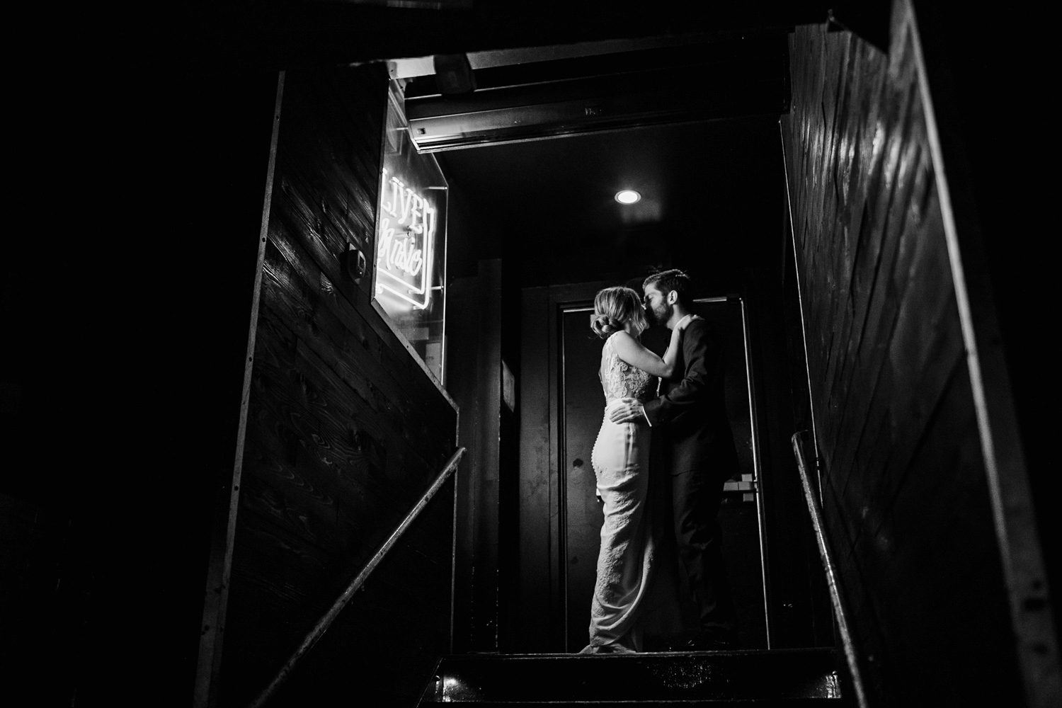 A bride and groom share a kiss in their favorite bar before a Gallery Marchetti wedding.