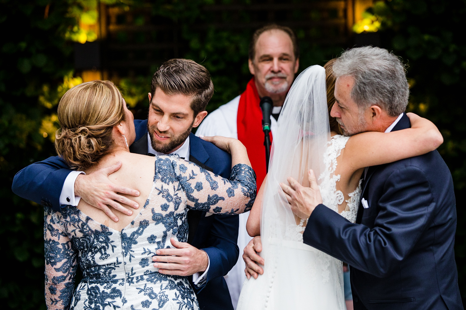 A bride and groom hug her parents during a Gallery Marchetti wedding.