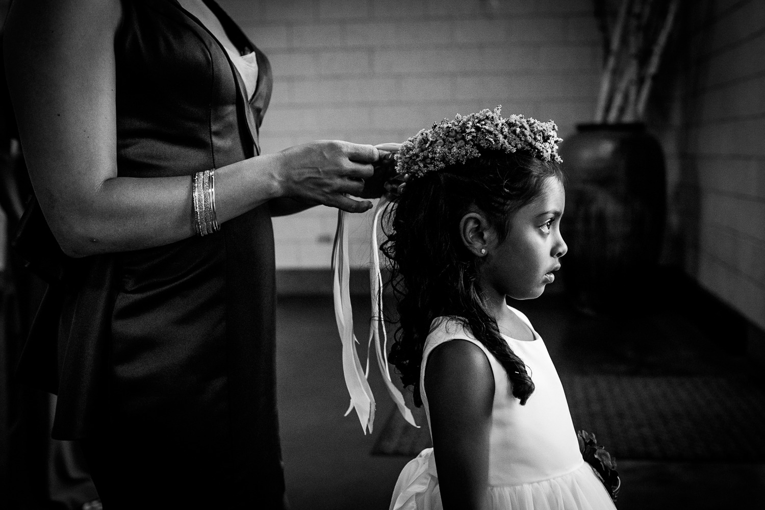 A flower girl has flowers put in her hair at a Garfield Park Conservatory wedding. 