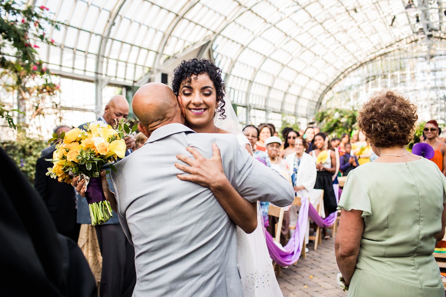 A bride hugs her father during a Garfield Park Conservatory wedding ceremony.