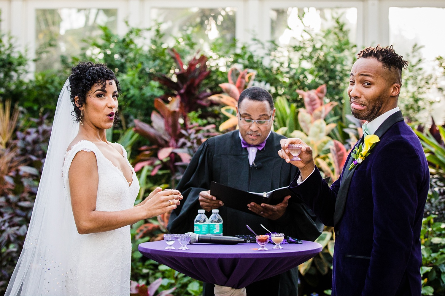 A bride and groom react during a tasting of the elements ceremony at a Garfield Park Conservatory wedding.