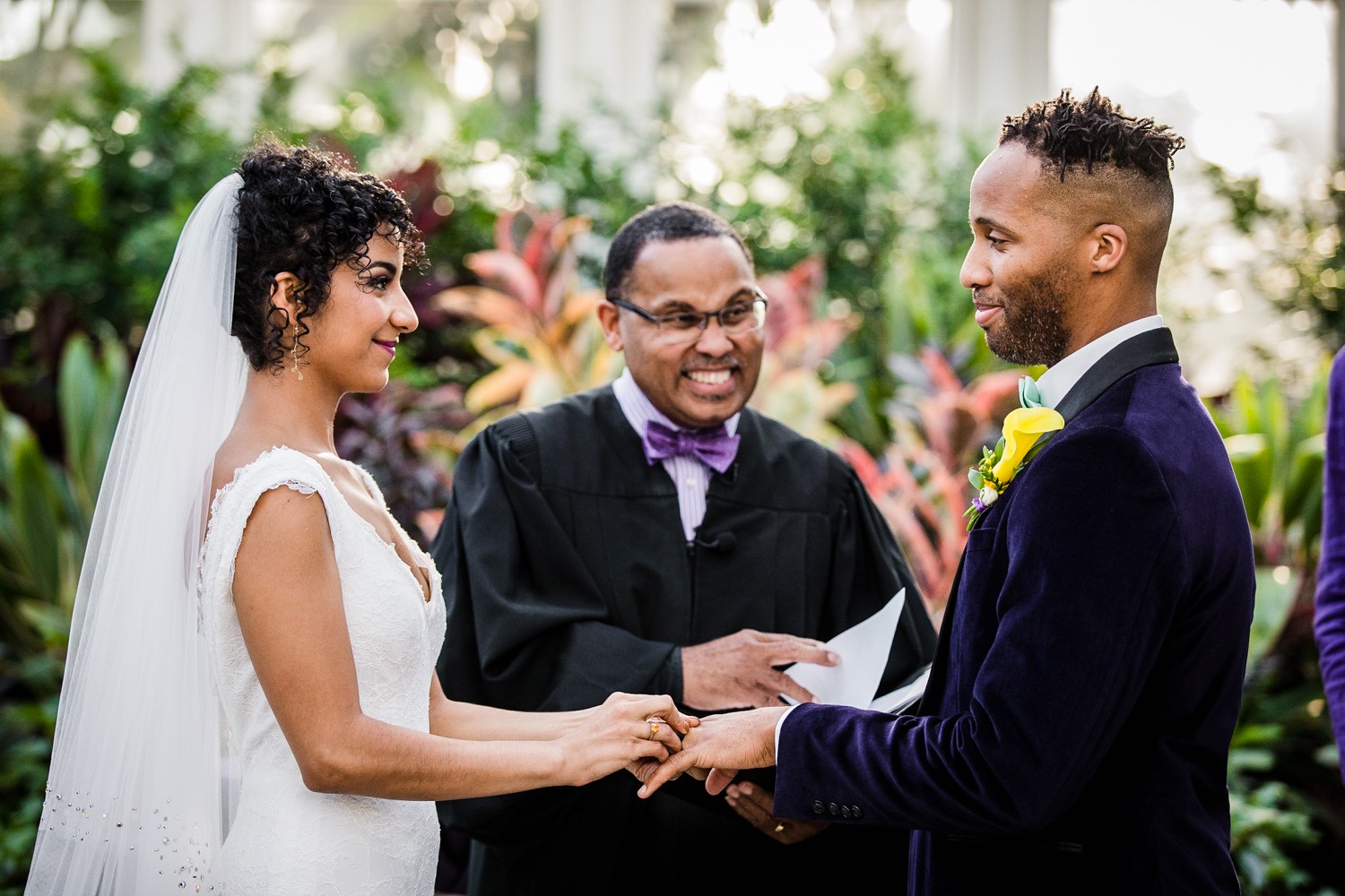 A couple exchanges rings during a Garfield Park Conservatory wedding.