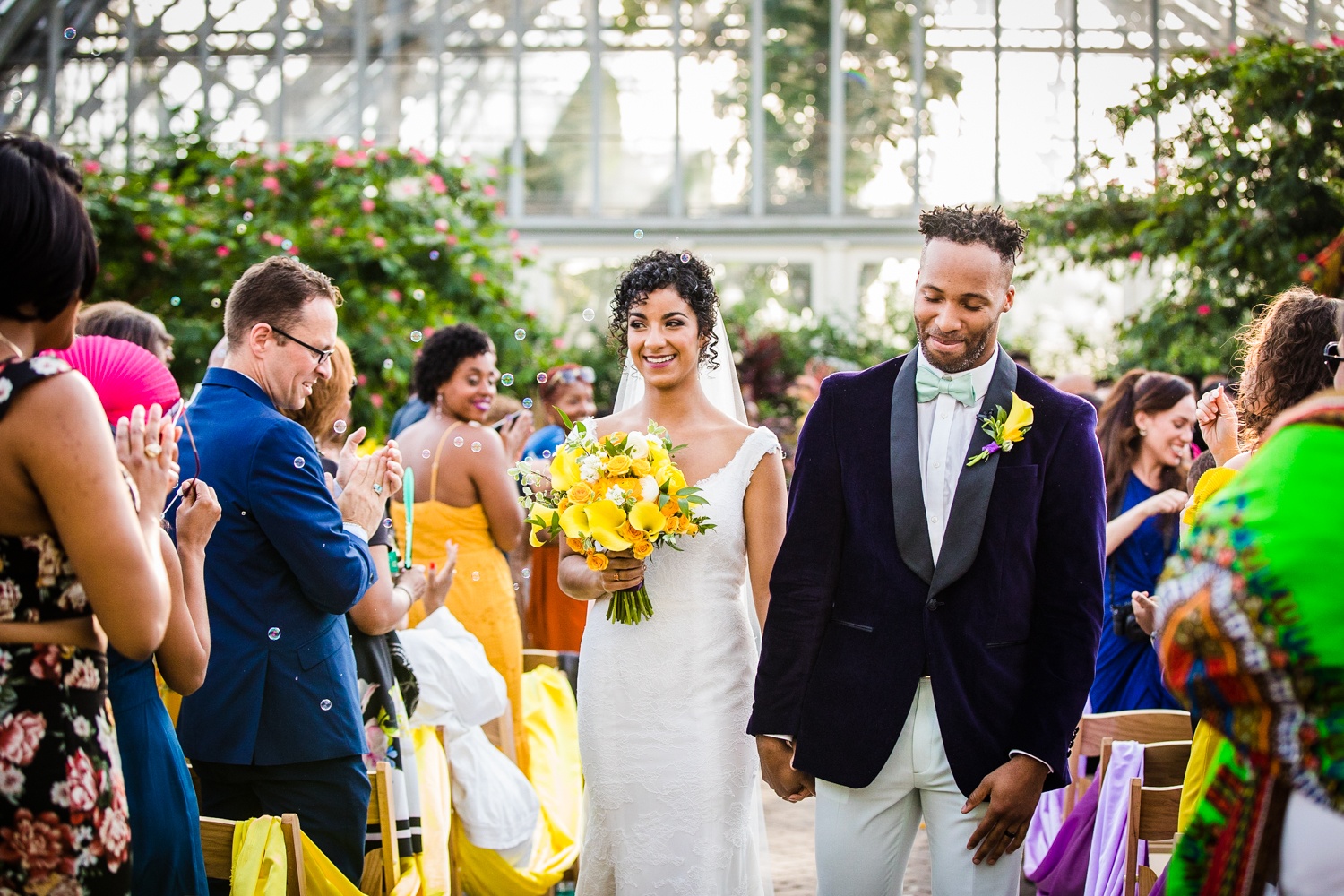 A couple walks down the aisle at the end of their Garfield Park Conservatory wedding.