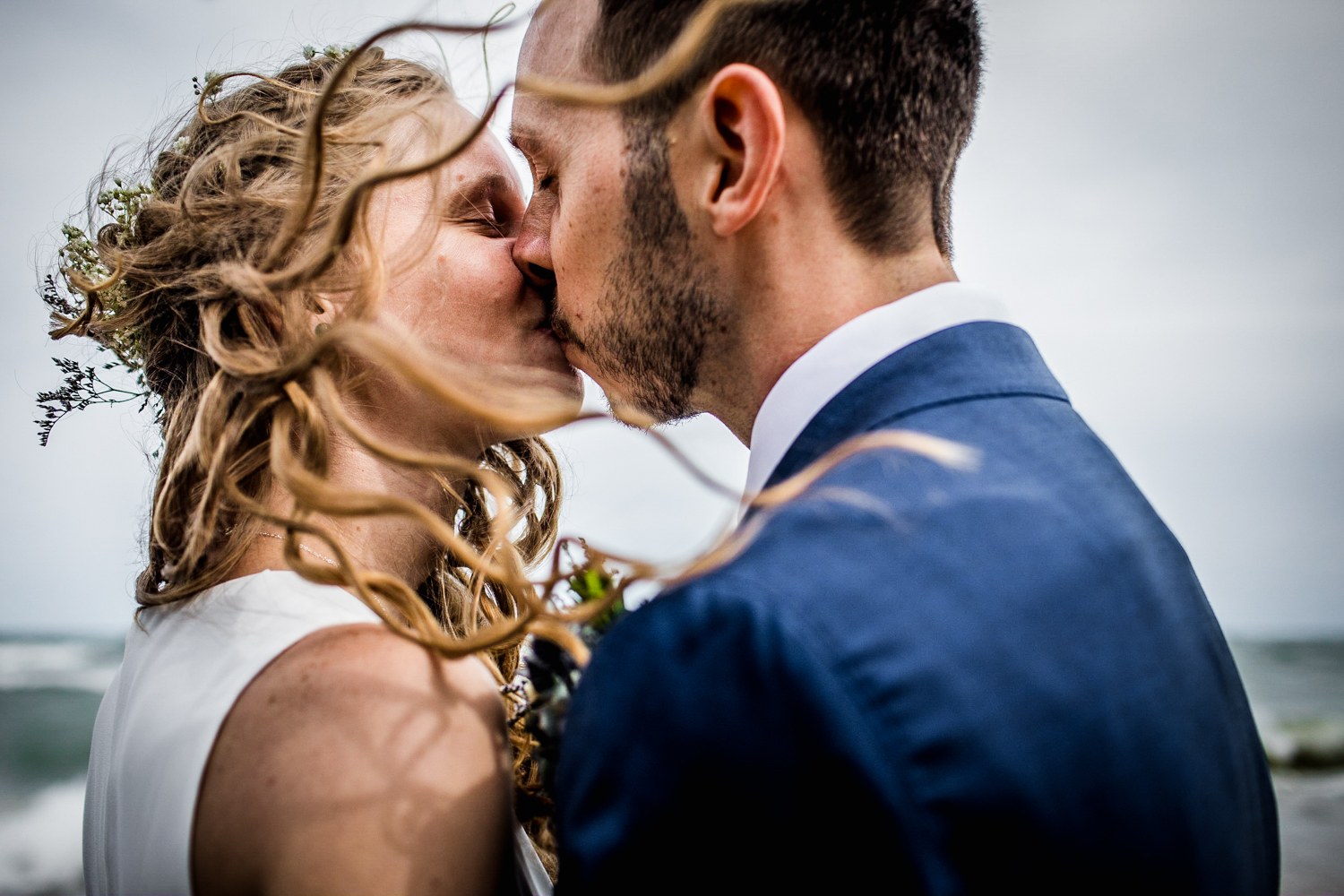 A couple kisses in the wind at an Illinois Beach Resort wedding