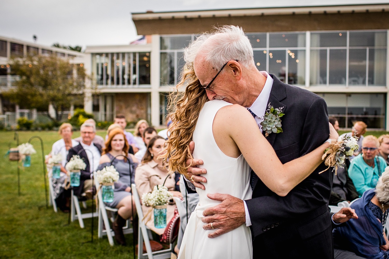 A bride hugs her father during an Illinois Beach Resort wedding ceremony.