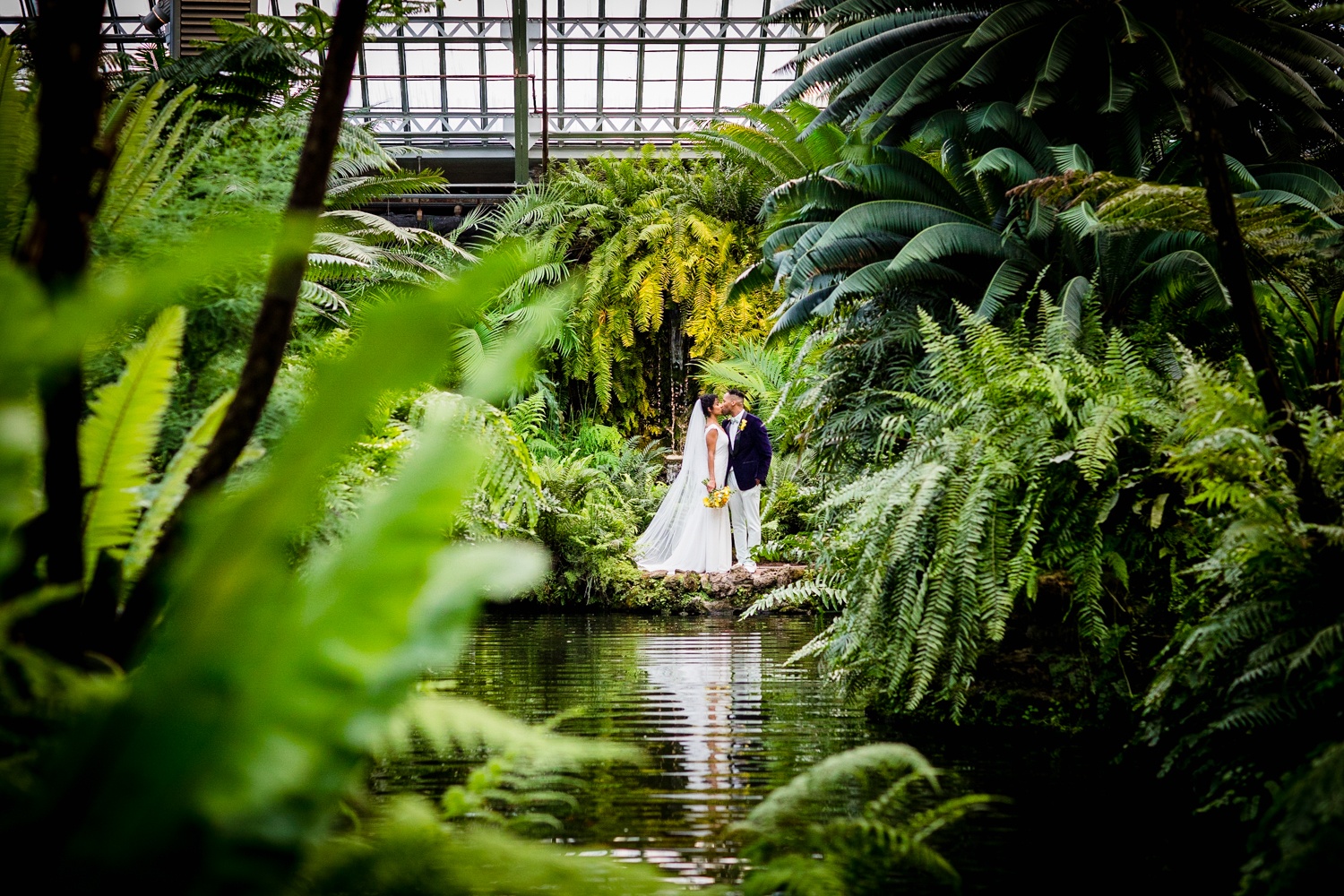 A couple kisses during a Garfield Park Conservatory wedding. 