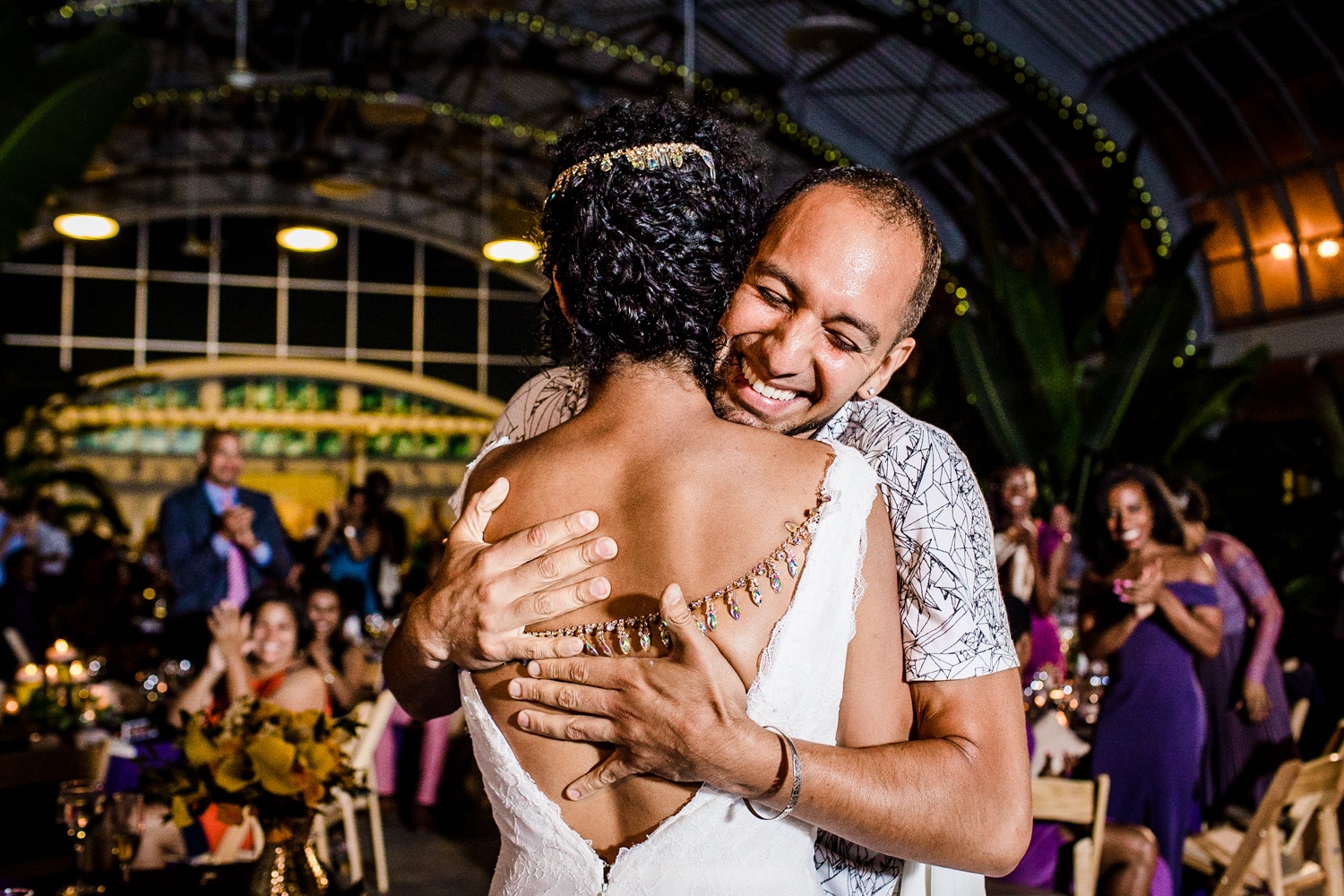 A bride and her brother share a hug during a Garfield Park Conservatory wedding. 