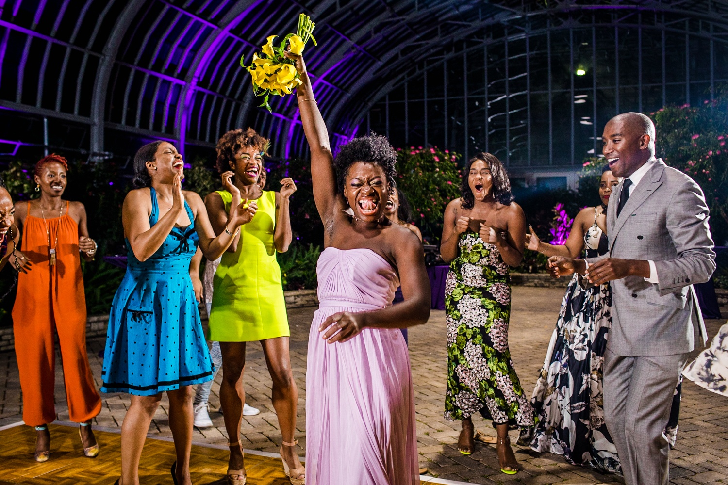 A bridesmaid reacts after catching a bouquet at a Garfield Park Conservatory wedding. 