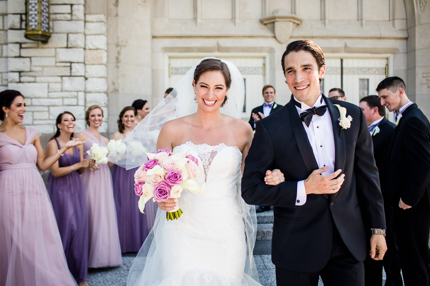 A bride and groom laugh together after a Queen of All Saints Basilica wedding ceremony. 
