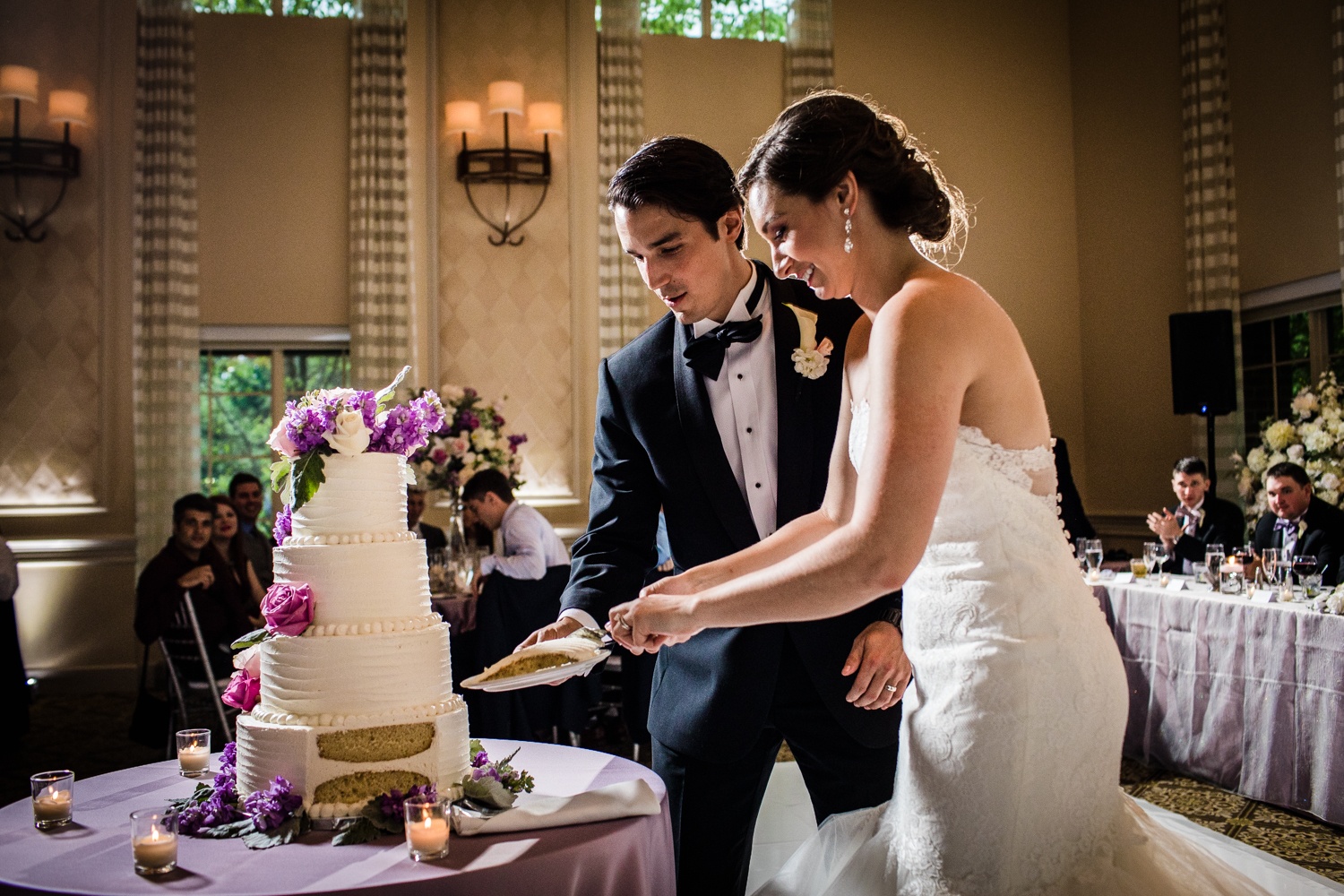 A couple cuts their wedding cake during a Glen Club wedding reception. 