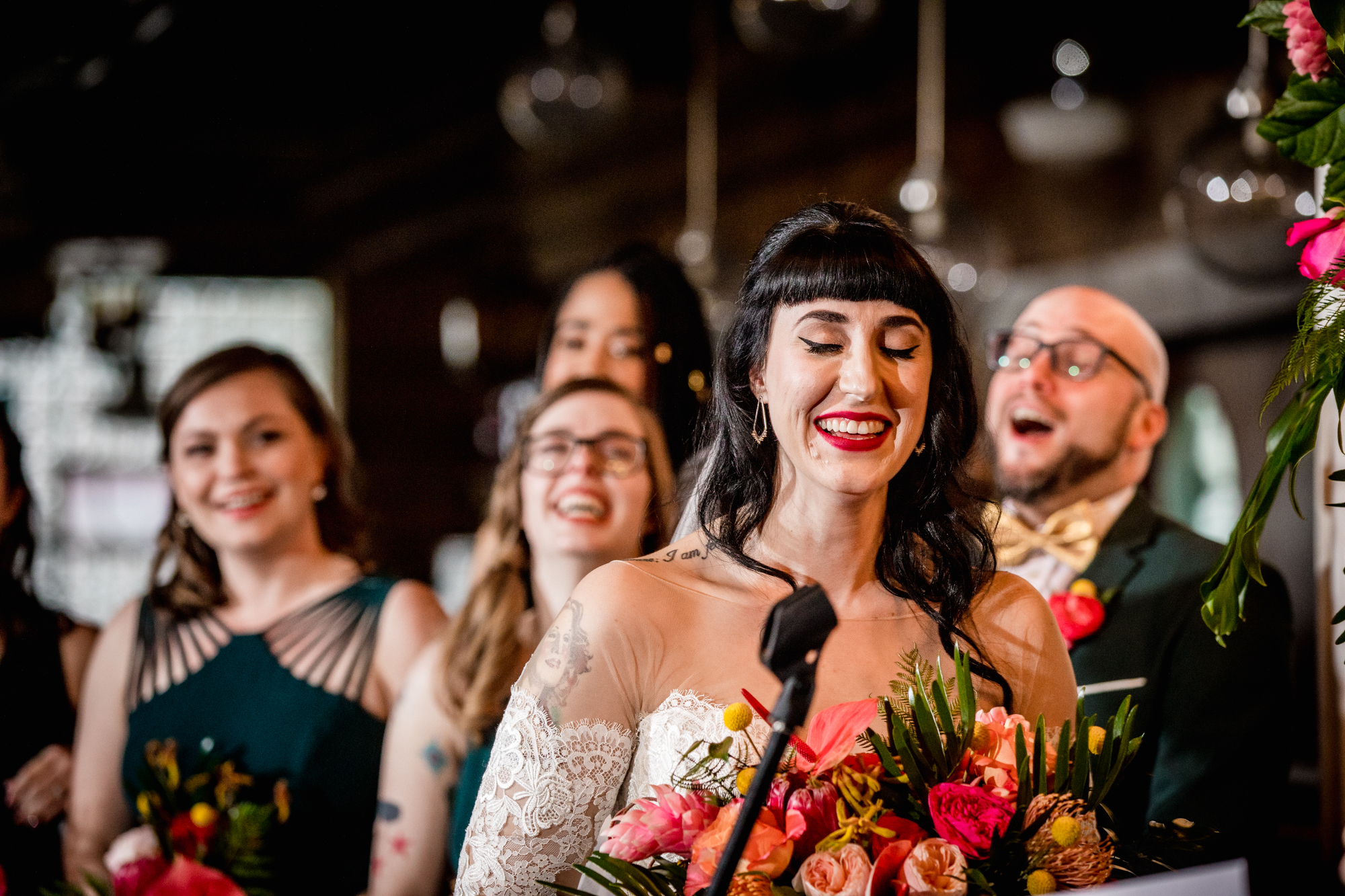 A bride and her wedding party laugh during a reading at a Salvage One wedding in Chicago. 