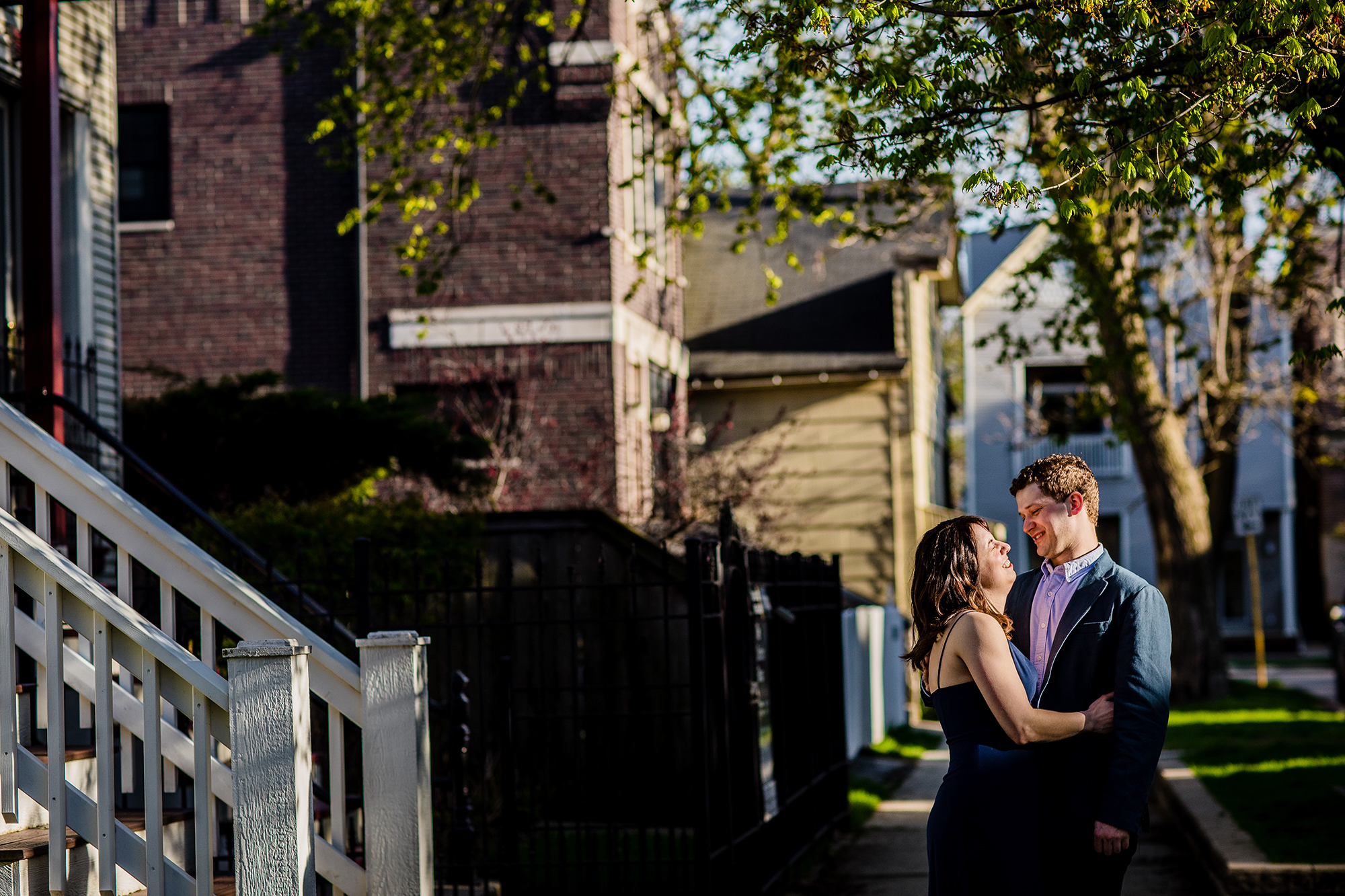 A couple laughs together in the sunset during a Roscoe Village engagement session. 