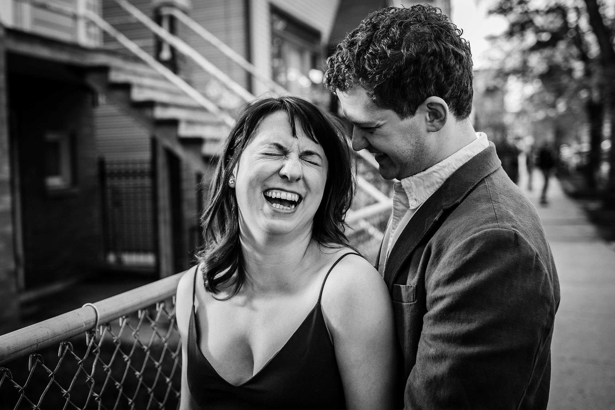 A couple laughs together during a Roscoe Village engagement session. 