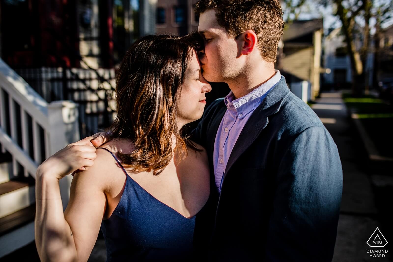 A couples kisses in the sunlight during a Roscoe Village engagement session. 