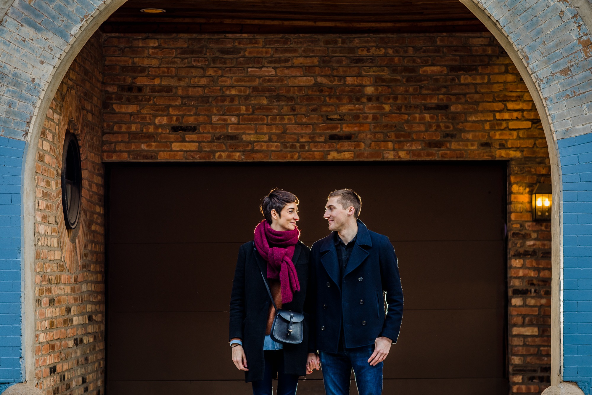 A couple looks at each other in front of a blue building in Wicker Park