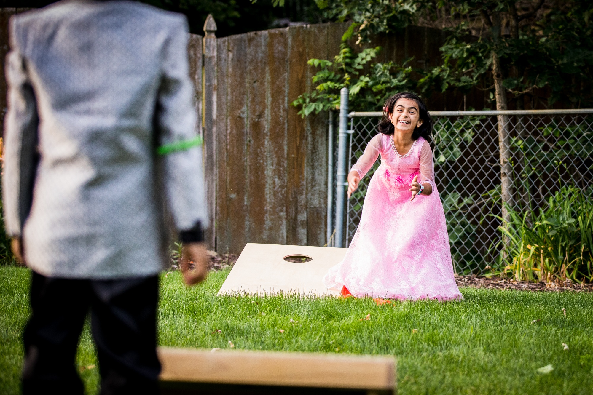 A child plays bags at a backyard wedding in Yorkville, Illinois