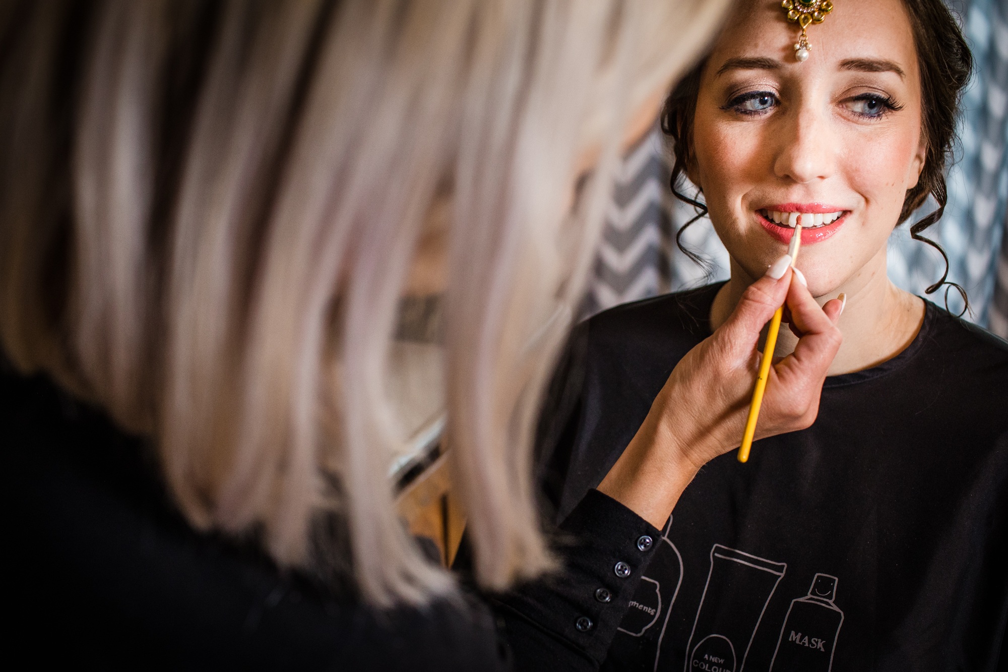 A bride has her makeup done before her Aurora Balaji Temple wedding
