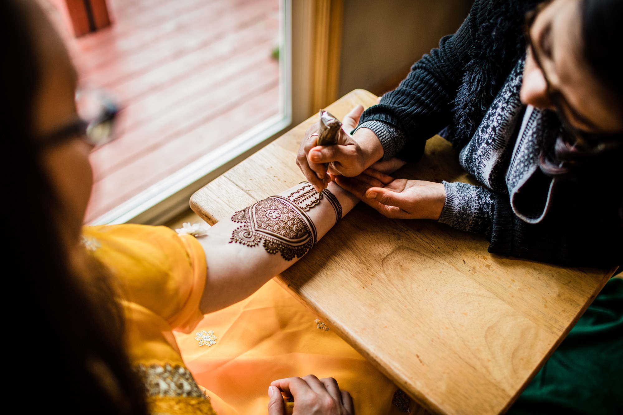 A bride has henna done by Unnati Shah