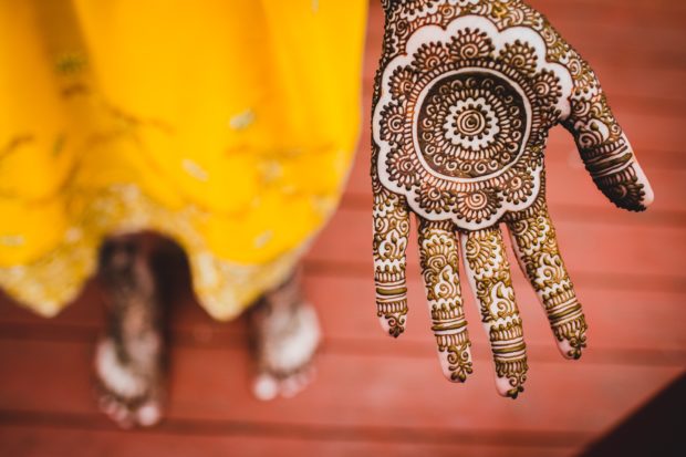 A bride shows henna on her hand done by Unnati Shah