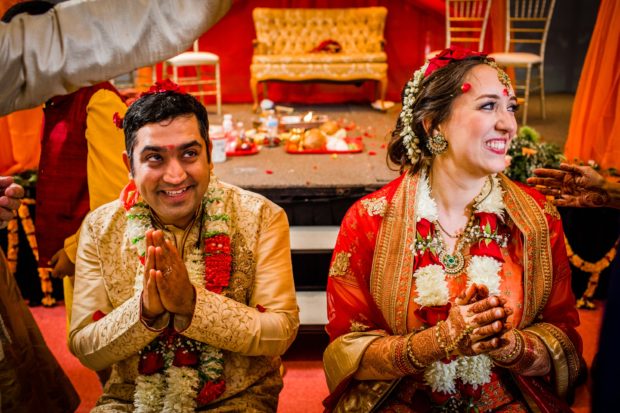 Guests throw rice on a couple during an Aurora Balaji Temple wedding