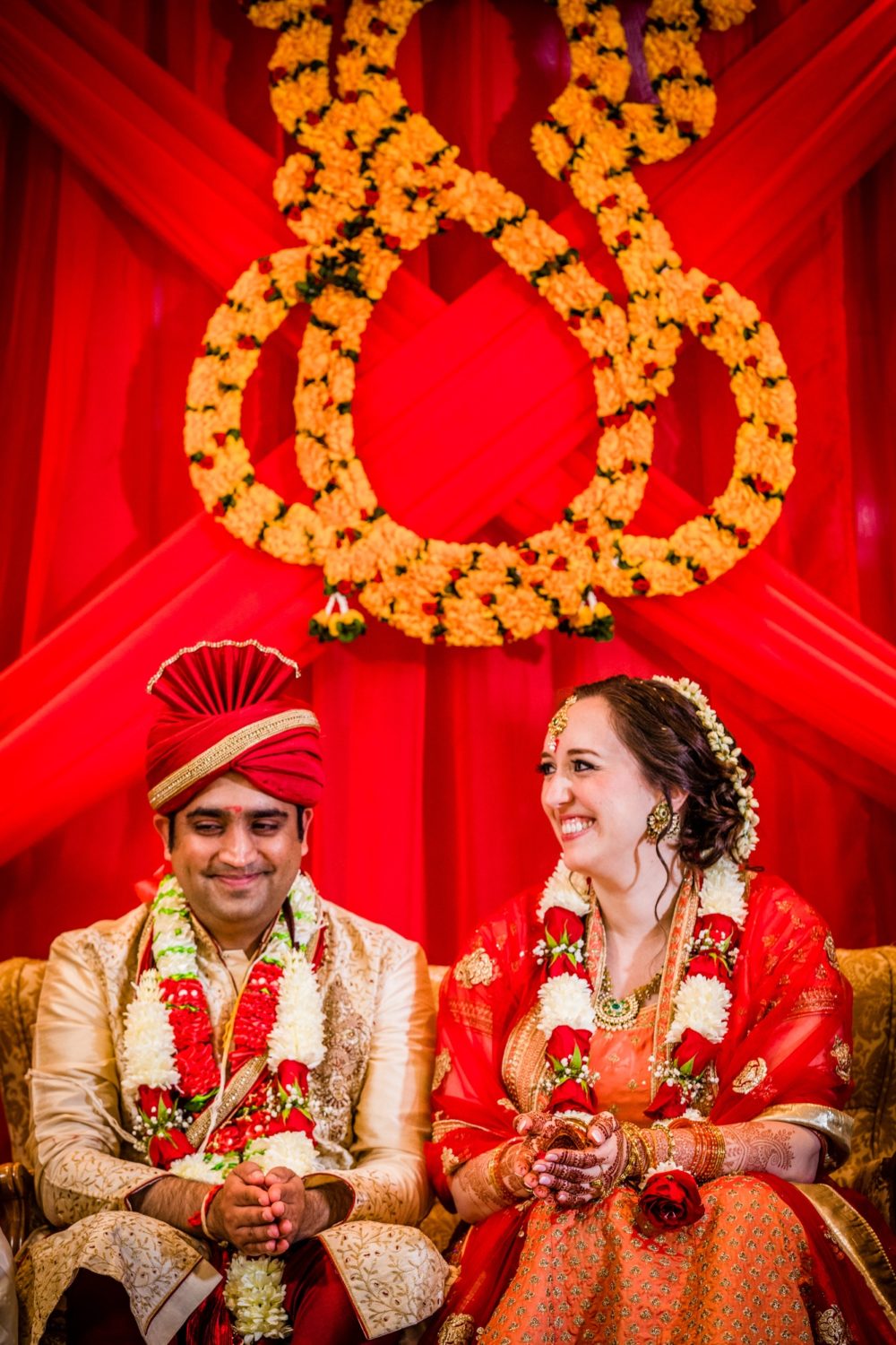 A bride and groom laugh together during an Aurora Balaji Temple wedding