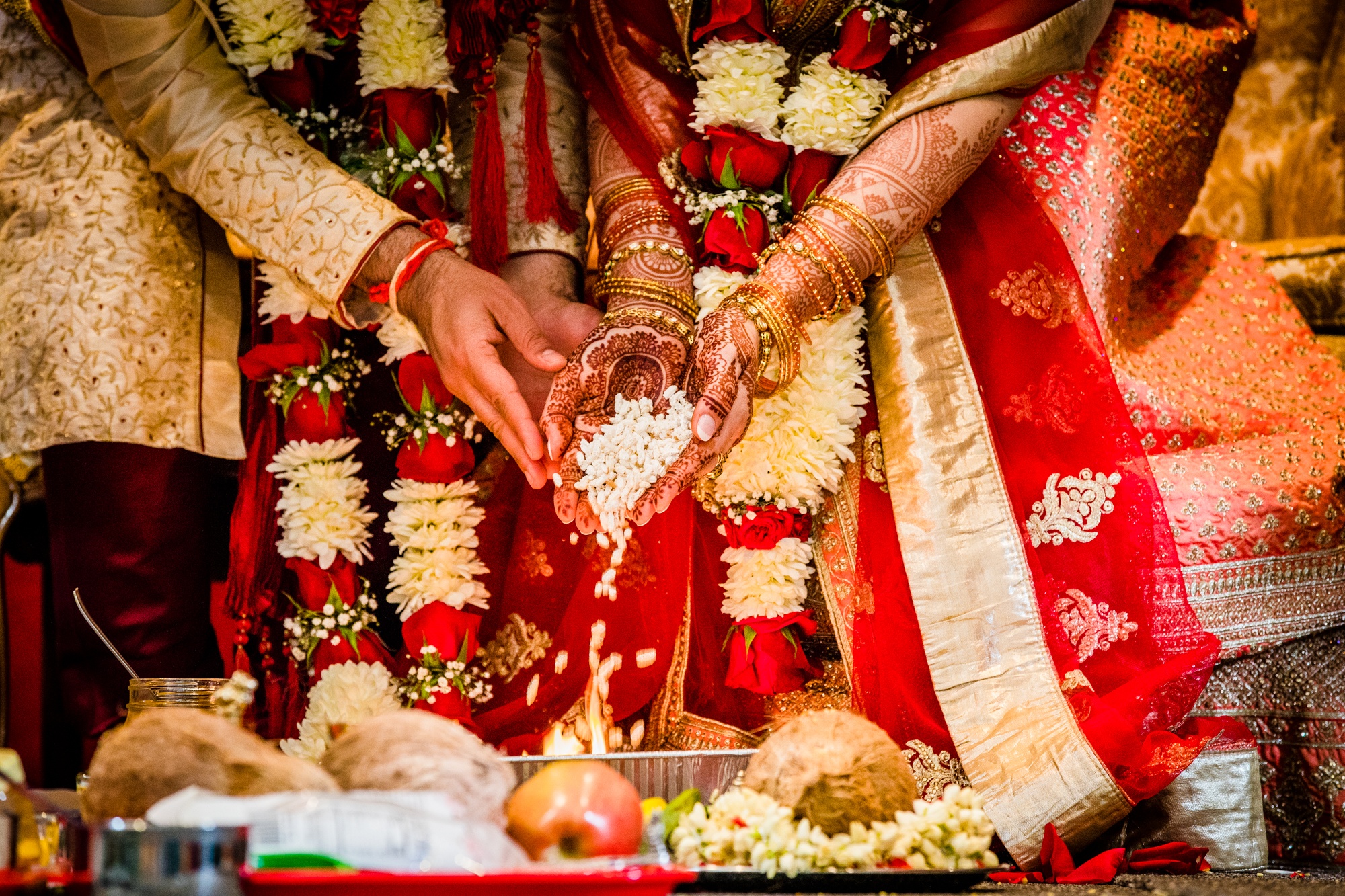 A couple makes a fire offering during an Aurora Balaji Temple wedding