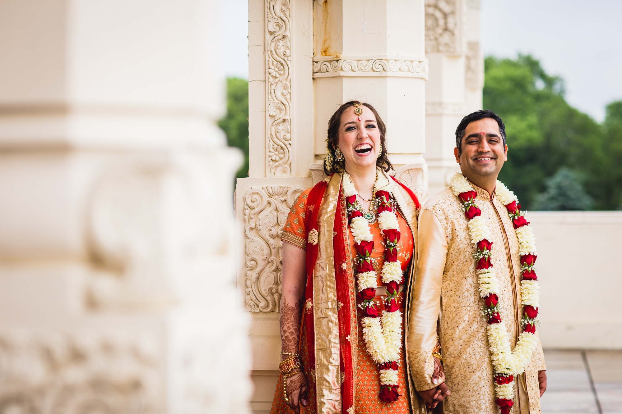A couple laughs together after a wedding ceremony at the Aurora Balaji Temple.