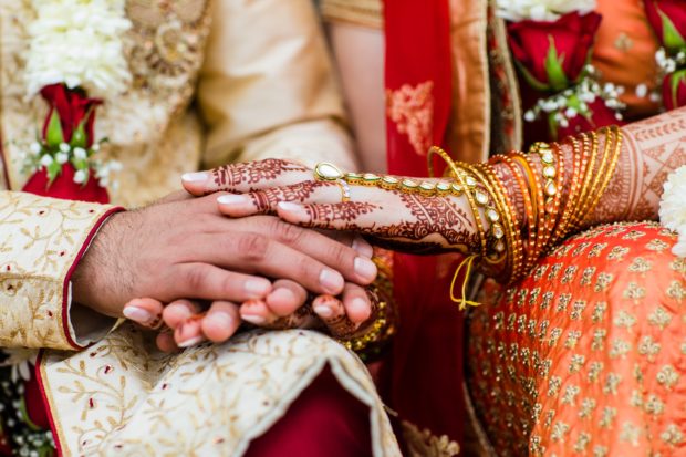 A close-up of a couple's hands at Aurora Balaji Temple