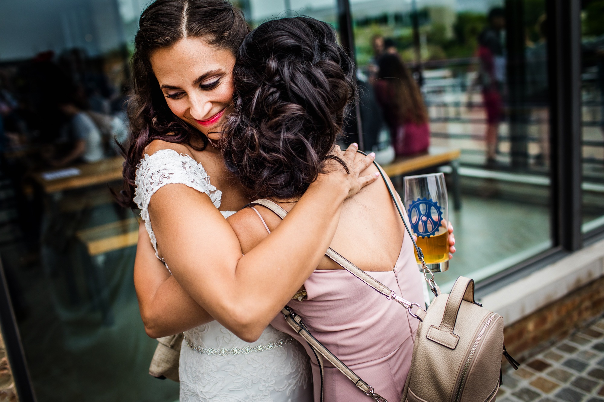 A bride hugs her friend at Metropolitan Brewing before their wedding