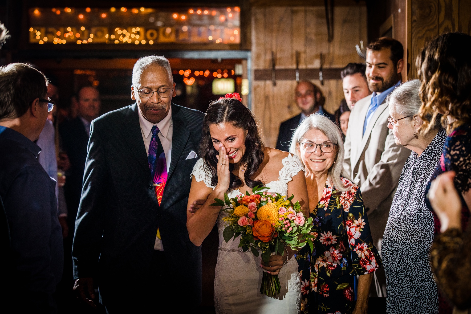 A bride walks down the aisle with her parents at a Hideout Chicago wedding