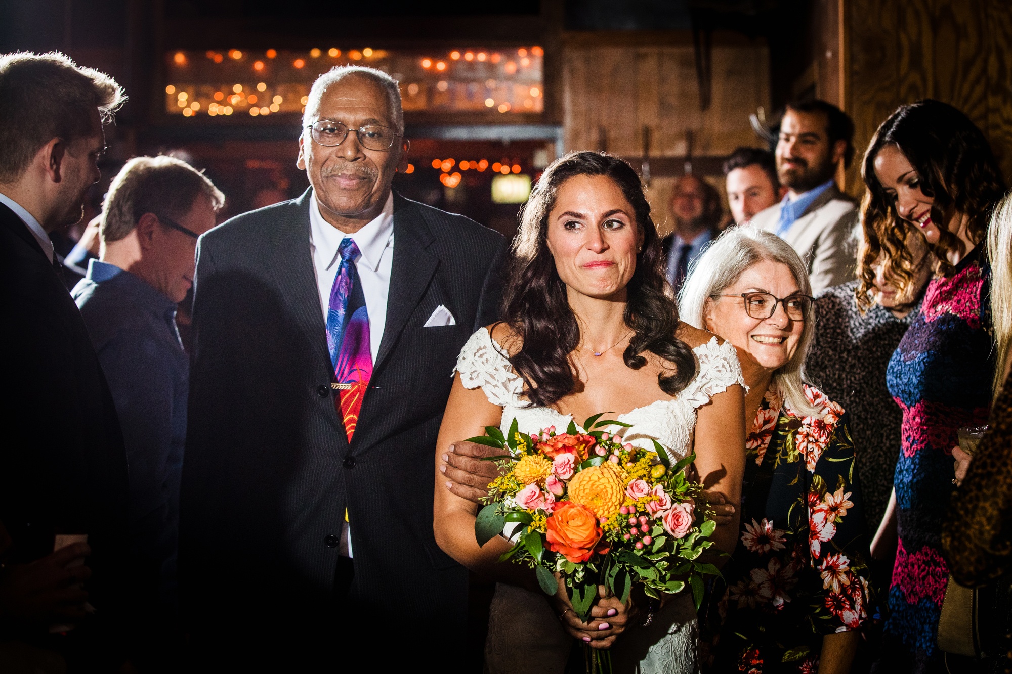 A bride walks down the aisle with her parents at a Hideout Chicago wedding