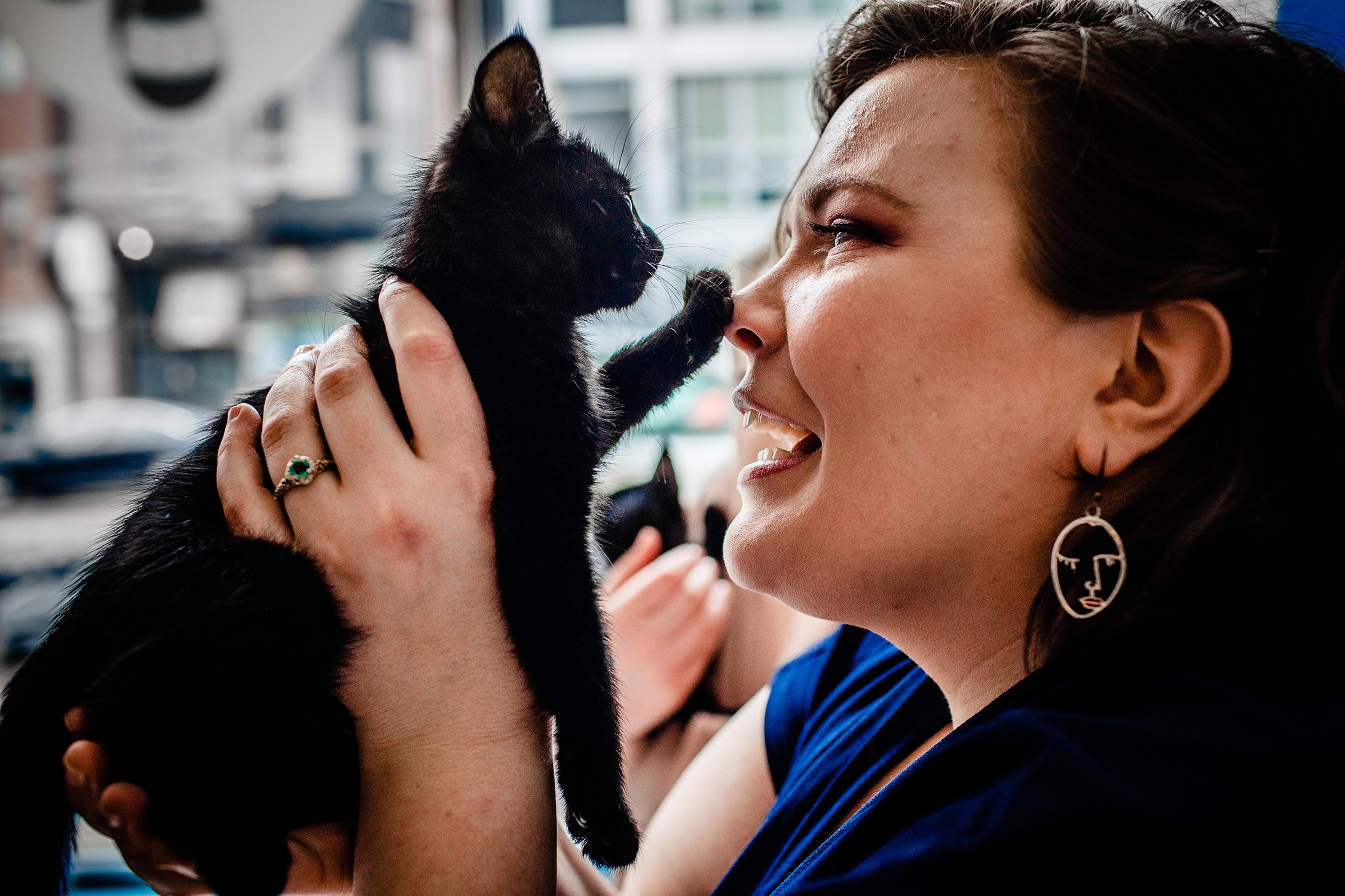 A couple plays with kittens during a cat cafe engagement session in Chicago.