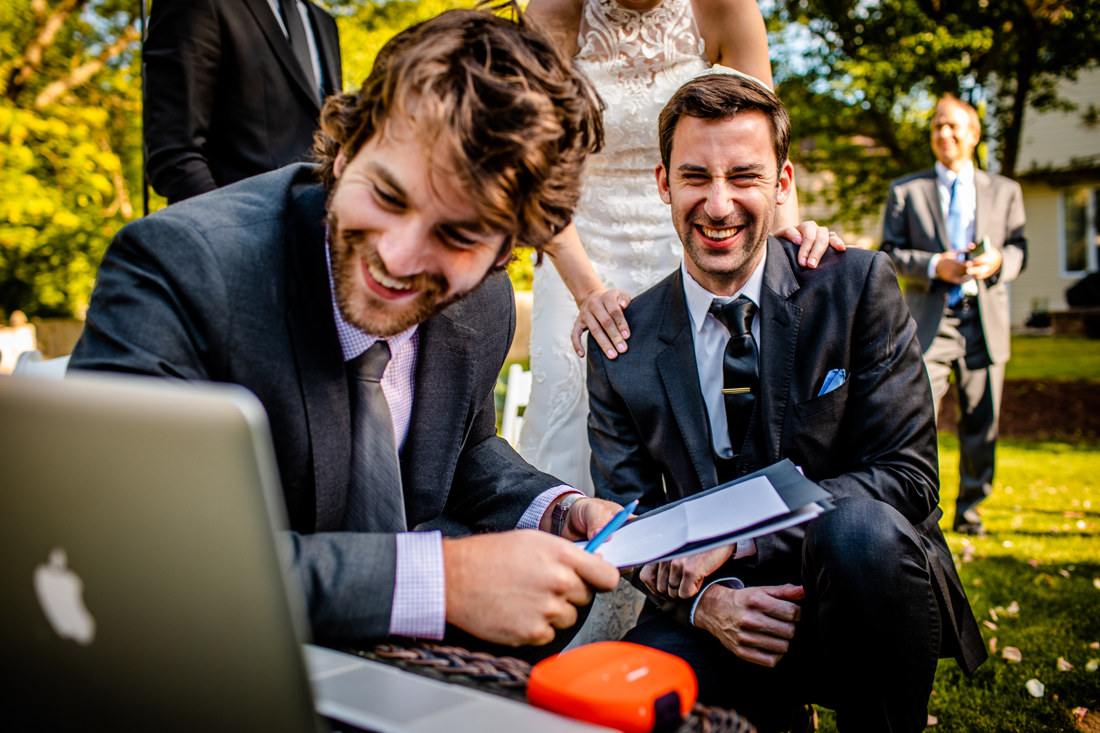 A groom laughs while talking to his grandmother over Zoom during a Naperville micro wedding.