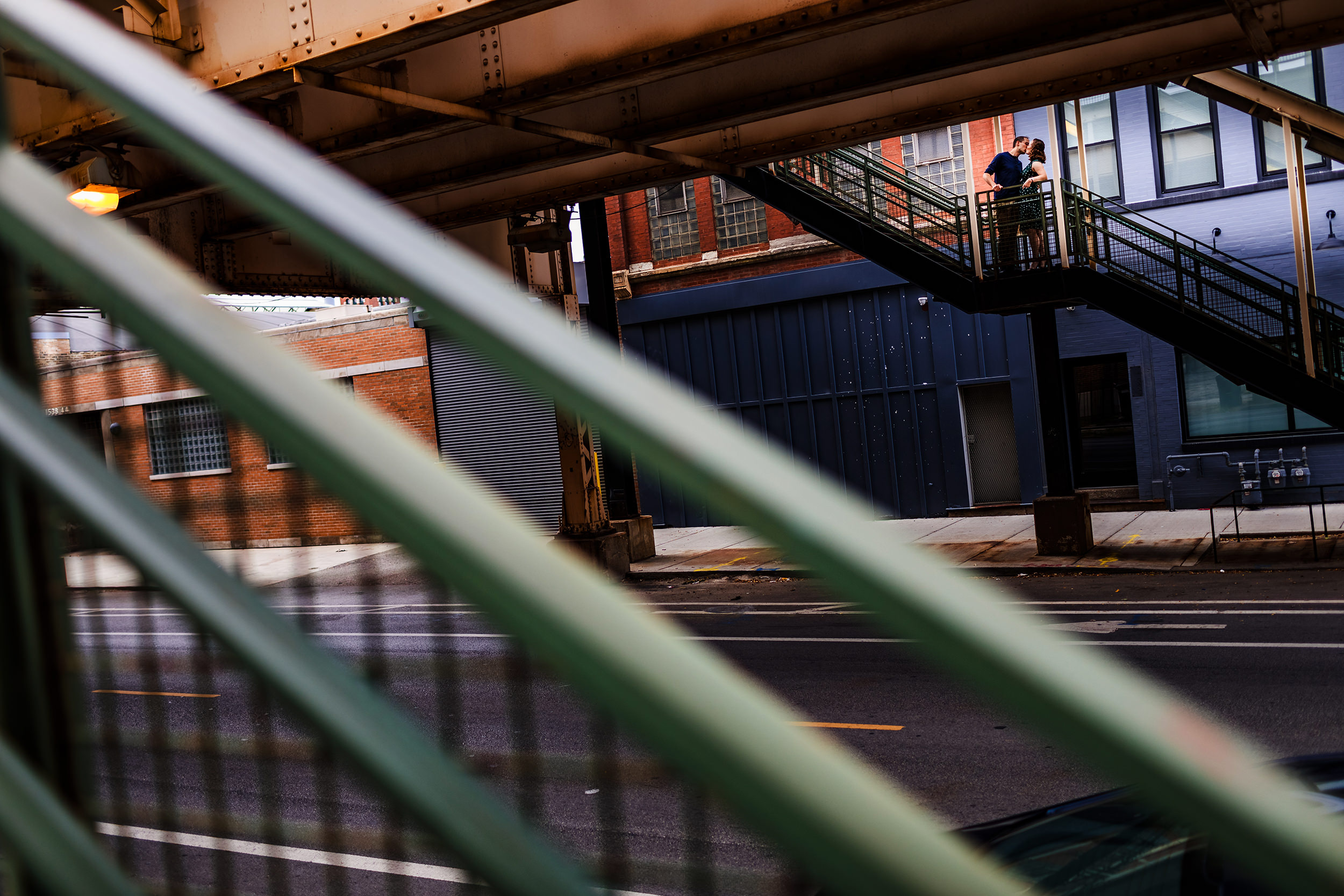 A couple kisses each other on the stairs to the Green Line during an engagement session on Lake Street. 