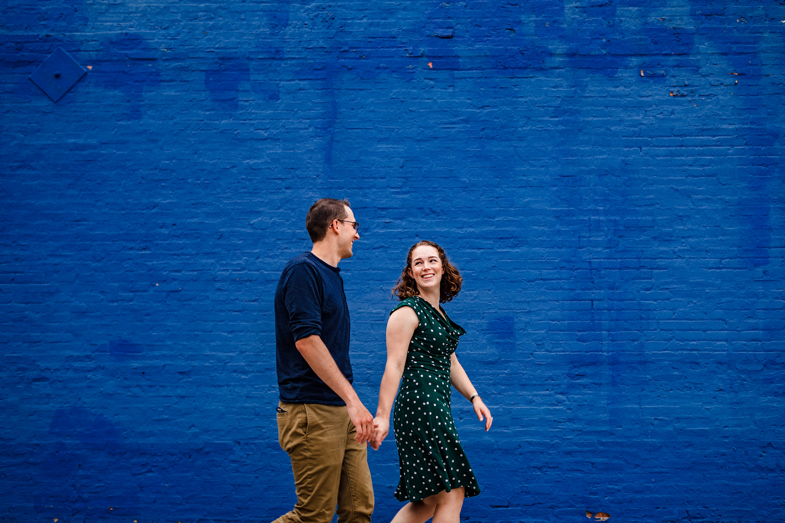 A couple holds hands while laughing during a West Loop engagement session in Chicago. 